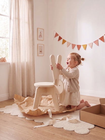 Meisje pakt het houten kinderstoeltje Kiko het Konijn van Studio Verdi blij uit als cadeau, met kraftpapier en linnen lint