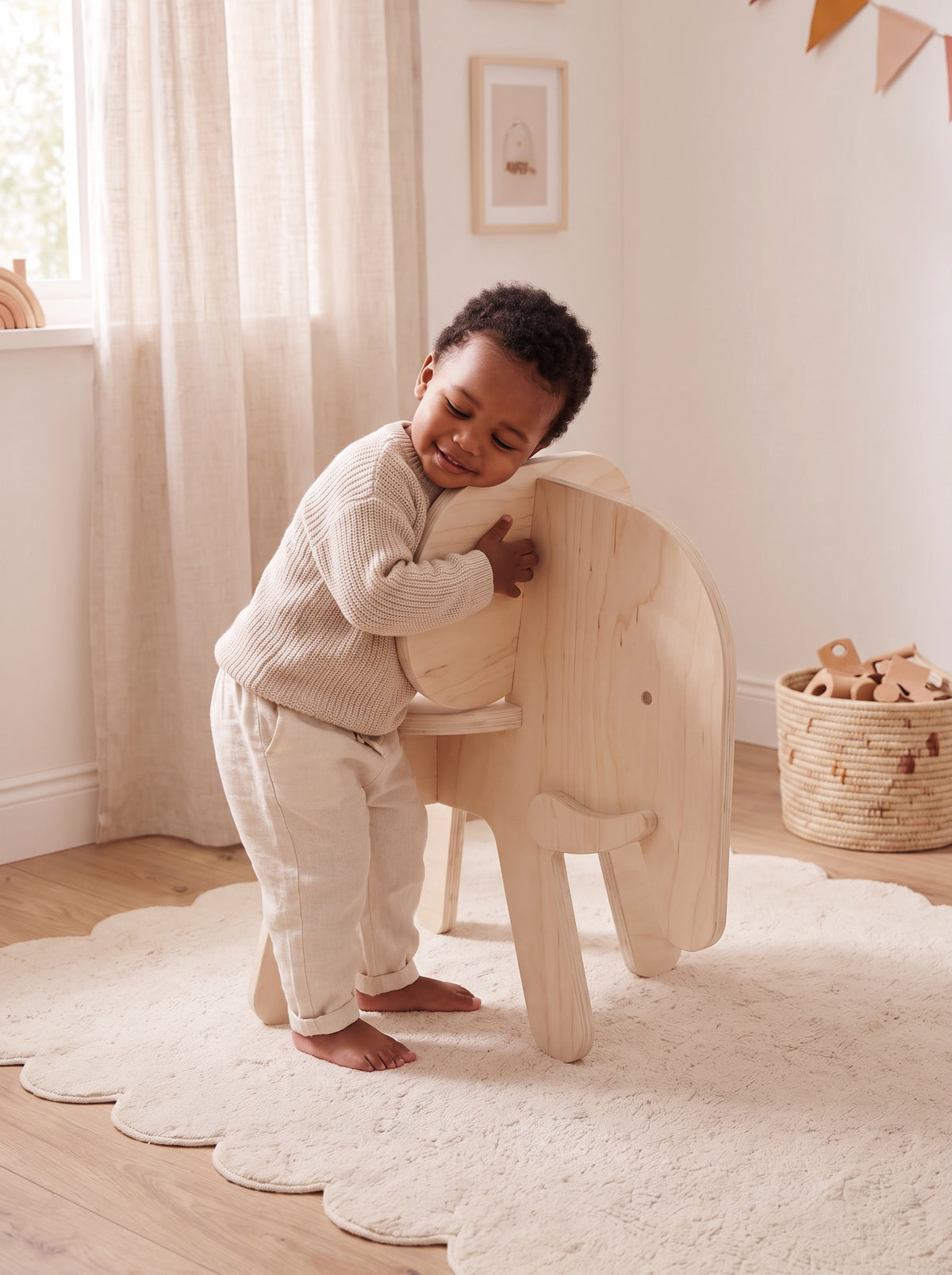 Peuter knuffelt het houten kinderstoeltje Ollie de Olifant van Studio Verdi in een lichte kinderkamer