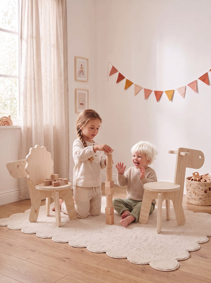 Twee kinderen bouwen een toren van houten blokken tussen de houten kinderstoeltjes Lio de Leeuw en Eddy de Eland van Studio Verdi